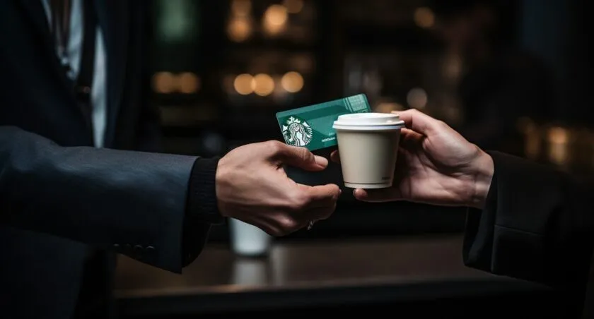 Hands Exchanging A Starbucks Gift Card For Bitcoin